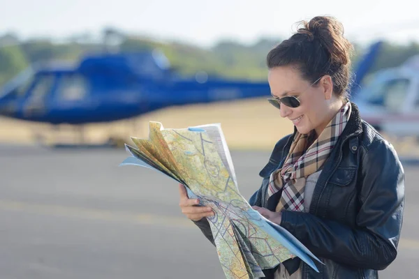 Young woman helicopter pilot reading map — Stock Photo, Image