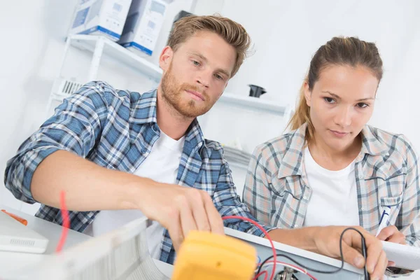 Dos trabajadores que trabajan en un taller de mantenimiento electrónico —  Fotos de Stock