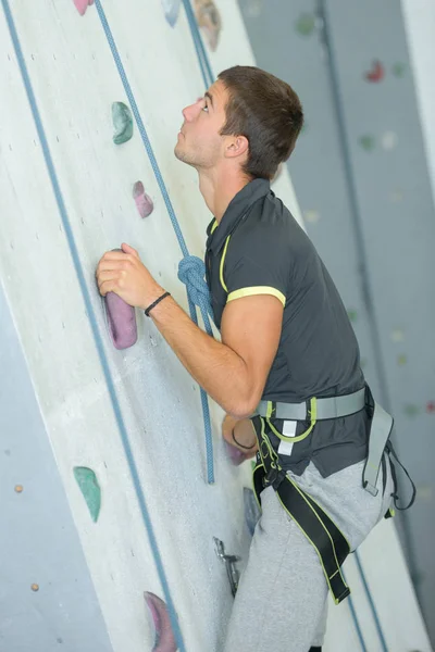 Jeune homme escalade un mur — Photo