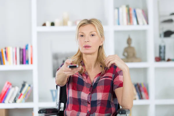 Mujer en silla de ruedas viendo la televisión — Foto de Stock