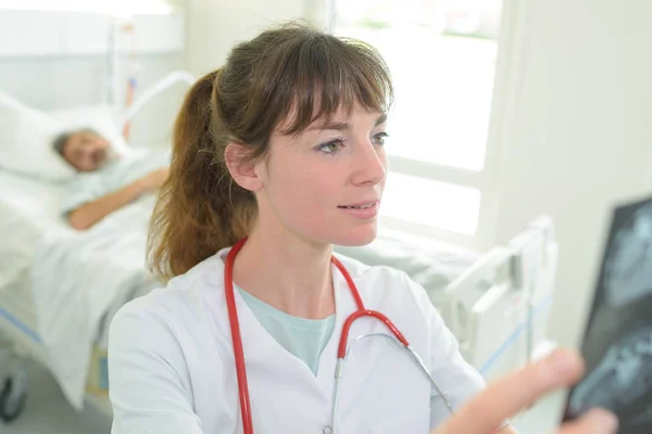 Jeune femme médecin regardant l'image radiographique — Photo