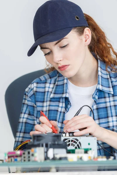 Genç kadın teknoloji elektronik cihaz servis merkezinde sınar. — Stok fotoğraf