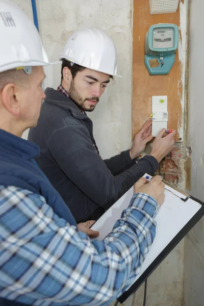 Elektriker lärling arbetare med växling i elektrisk säkring styrelsen — Stockfoto