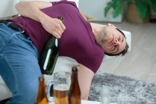 Betrunkener Geschäftsmann schläft mit Wodka-Flasche auf Sofa — Stockfoto