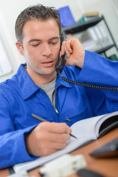 Trabajador manual haciendo una llamada en la oficina —  Fotos de Stock