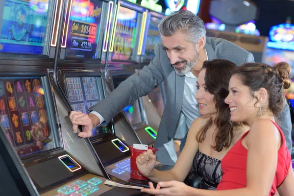 Grupo de pessoas jogando em um slot em um cassino — Fotografia de Stock