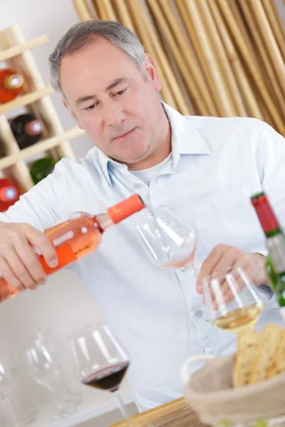 Winzer gießt Wein ins Glas im Weinkeller — Stockfoto