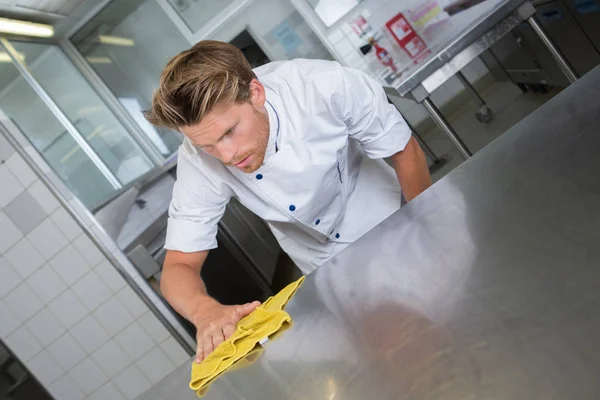 Αρσενικό σεφ καθαρισμό επιφάνεια εργασίας κουζινών ανοξείδωτου χάλυβα — Φωτογραφία Αρχείου