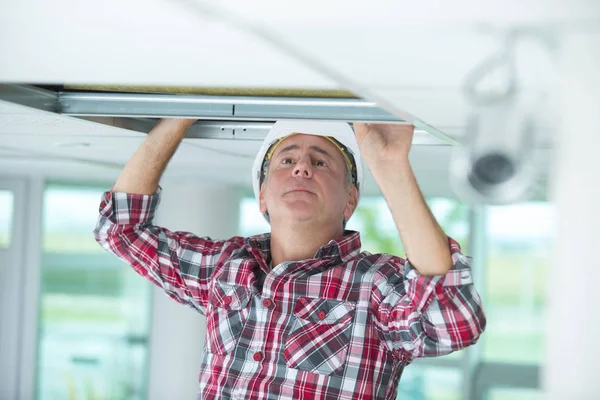 Man repareren samengevouwen plafond — Stockfoto