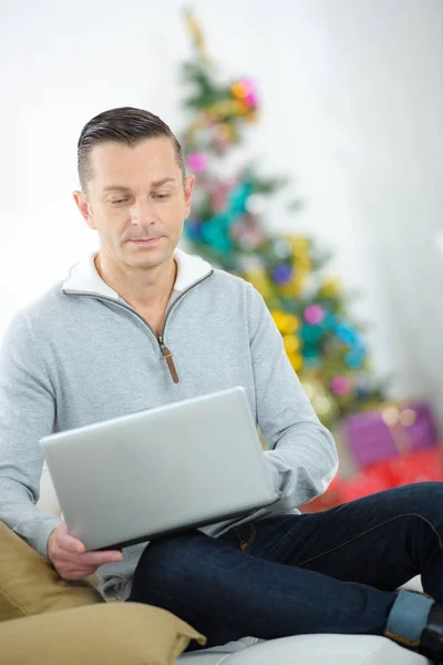 Hombre joven de compras en línea en casa para la Navidad —  Fotos de Stock