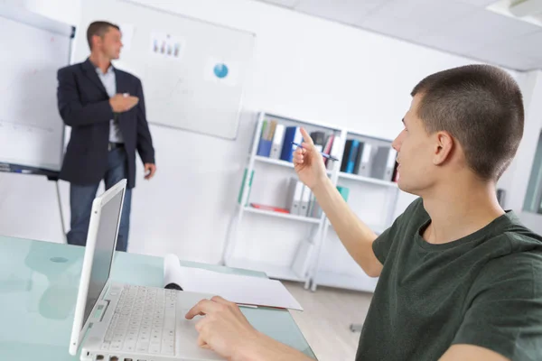 Enseignant avec bloc-notes montrant schéma sur tableau blanc en classe — Photo