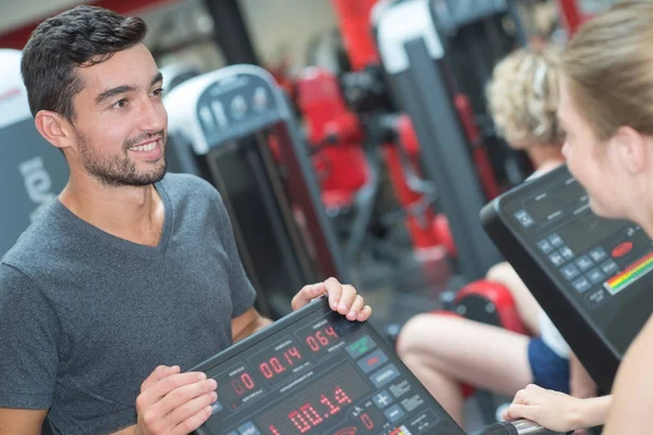 Tränare som inspekterar gym medlem prestanda — Stockfoto