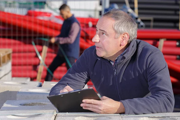 Мужчина архитектор, пишущий на планшете снаружи здания — стоковое фото