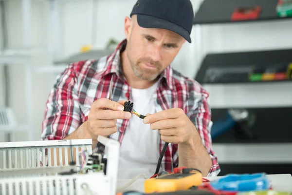 Technician repairing radiator in his workshop — Stock Photo, Image