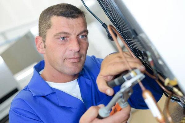 Reparatör arbetar på apparaten — Stockfoto