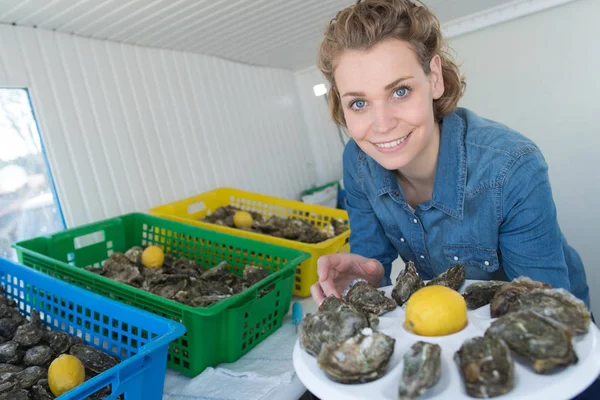 Lachende vrouw houden een lade van oesters — Stockfoto