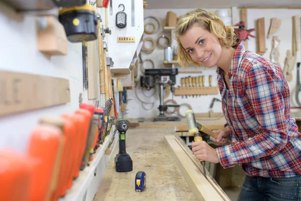 Ženské carpenter se usmívá na fotoaparát ve své dílně — Stock fotografie