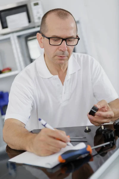 Technicien électroménager écrivant ses notes — Photo