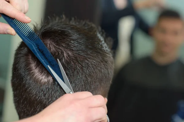 Coiffeur faisant coupe de cheveux au client dans le salon de coiffure — Photo