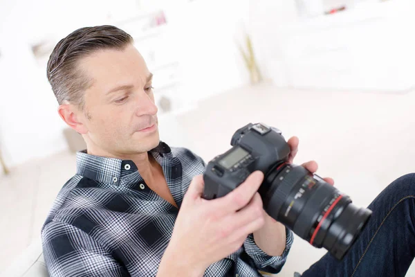 Fotógrafo en estudio con cámara dslr en la mano —  Fotos de Stock