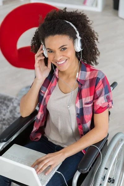 Uśmiechający się wyłączone kobieta na wózku inwalidzkim z laptopa — Zdjęcie stockowe