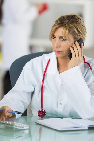 Portret van vrouwelijke arts met behulp van mobiele telefoon — Stockfoto