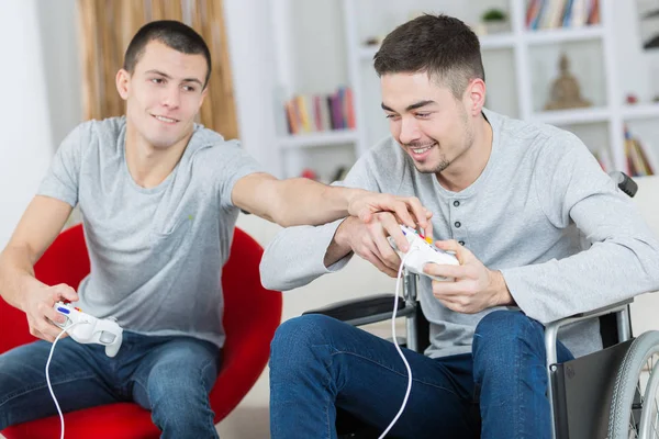 Young men playfully wrestling for computer controller — Stock Photo, Image