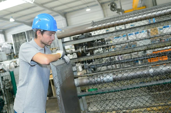 Trabalhador que supervisiona a produção de arame de esgrima — Fotografia de Stock