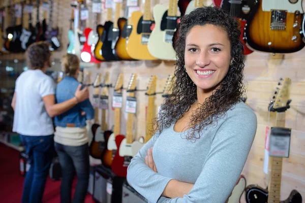 Portret van Verkoopassistent poseren in een muziekwinkel gitaar — Stockfoto