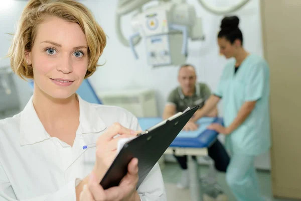 Médico fêmea feliz com área de transferência — Fotografia de Stock