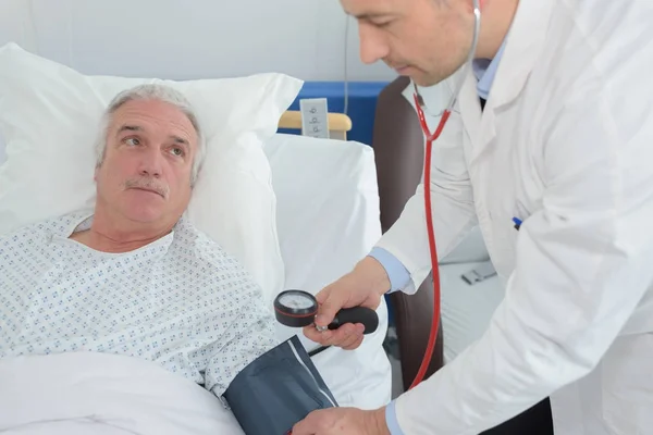 Врач осматривает пожилого пациента — стоковое фото