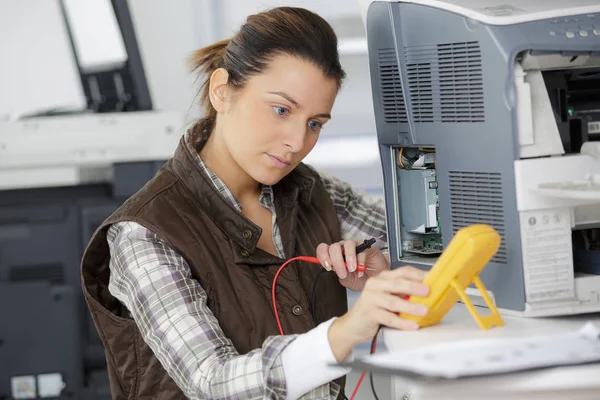 Handywoman checking computer with a multimeter — Stock Photo, Image