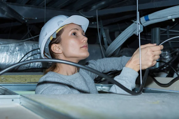 Mulher segurando cabos sobrecarga no telhado — Fotografia de Stock