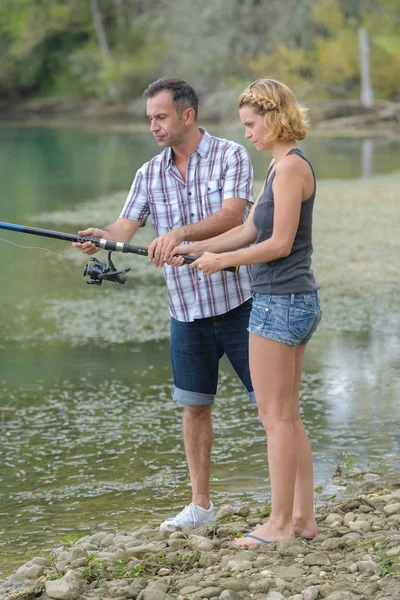 Pacífica jovem casal de pesca à beira da lagoa no outono — Fotografia de Stock