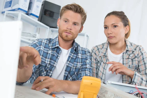 Lavoratori che controllano i risultati dei mutimetri — Foto Stock