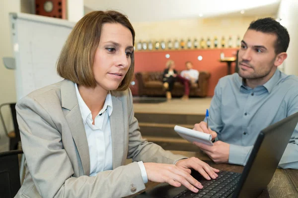 Frau tippt auf Laptop Mann saß aufmerksam mit Notizbuch — Stockfoto