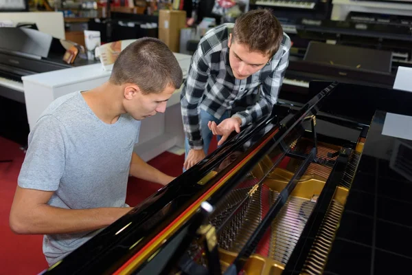 Концепция музыкального магазина с гитарами и фортепиано — стоковое фото