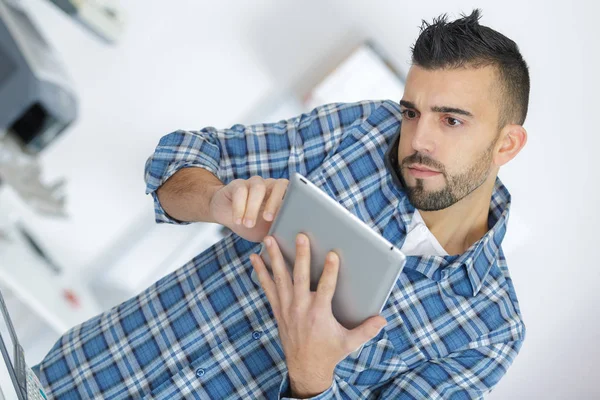 Homem segurando um tablet pc para encontrar problema — Fotografia de Stock