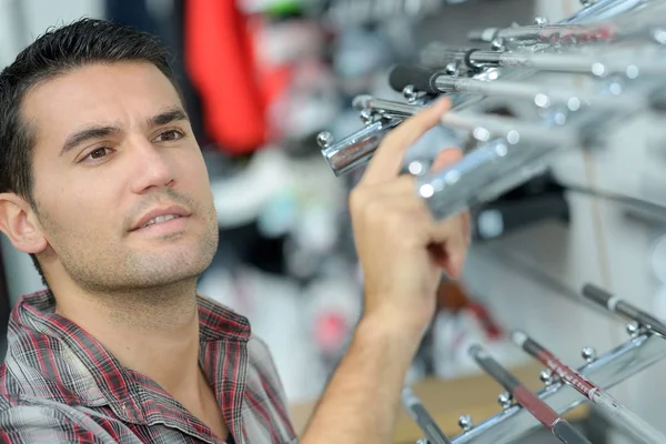 Trabalhador segurando detalhes de metal para moldura de imagem na oficina — Fotografia de Stock