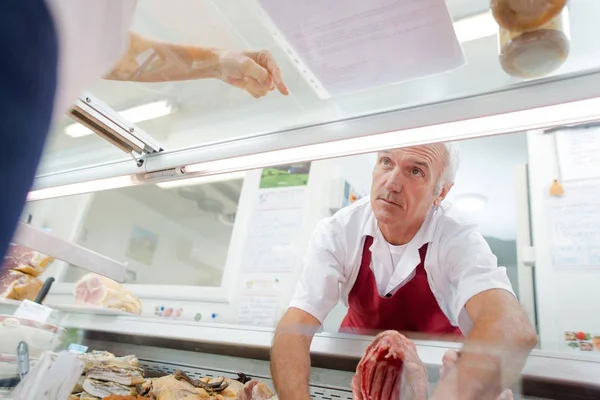 Metzger bedient einen Kunden — Stockfoto