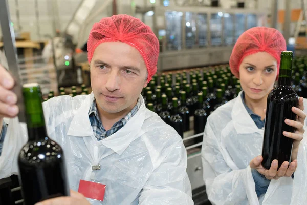 Werknemers bottelen van wijn en bottelen — Stockfoto