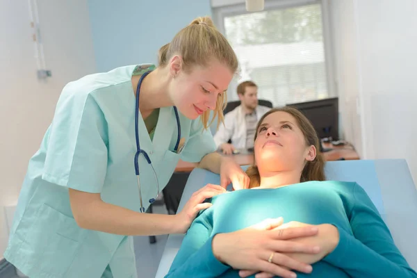 Lächelnde Schwangere mit ihrem Arzt im Krankenhauszimmer — Stockfoto