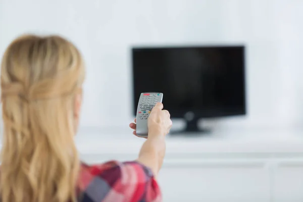 Frau sitzt zu Hause auf Couch und schaut Film im Fernsehen — Stockfoto