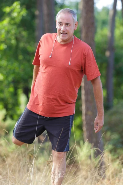 Senior man rekken en opwarmen voordat joggen oefening — Stockfoto
