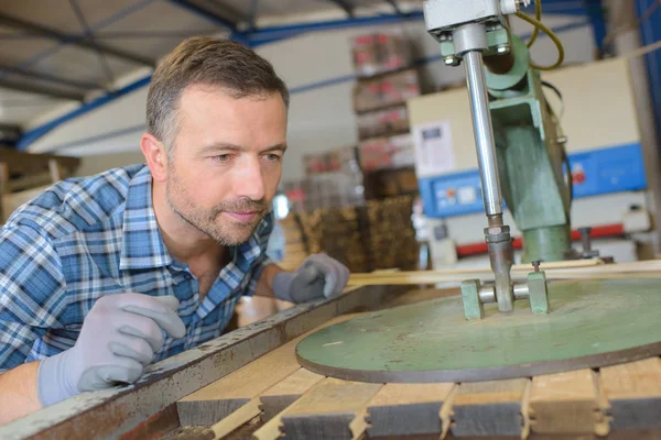 Cooper titta på maskinen tryck plankor av trä grupp — Stockfoto