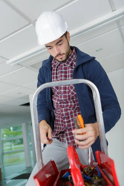 Jonge klusjesman in huis in de buurt van de muur — Stockfoto