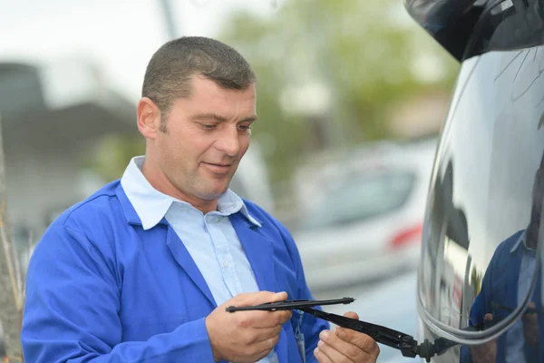 Uomo sta cambiando tergicristalli su un'auto — Foto Stock