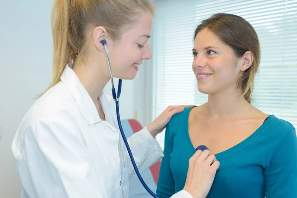 Läkaren lyssnar på patientens bröst med stetoskop — Stockfoto