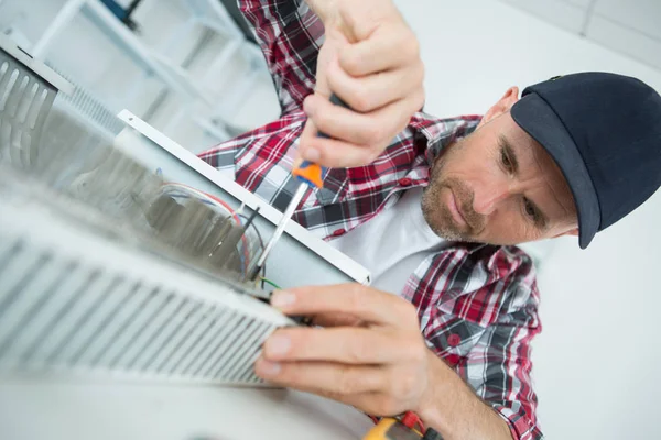 Homem jovem reparando radiador — Fotografia de Stock