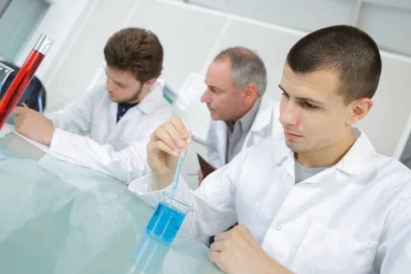 Professor supervisionando adolescentes realizando experimento de ciência — Fotografia de Stock